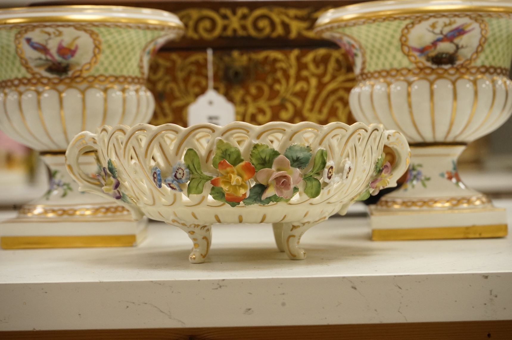 A pair of Dresden urns and a floral encrusted basket, tallest 15cm